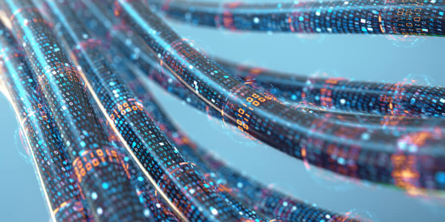 Un grupo de cables de fibra óptica con un efecto visual que deja claro que en su interior están transmitiendo datos a alta velocidad.