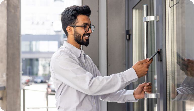 Un colaborador realiza check in en un control de acceso de su trabajo, con ayuda de una tarjeta.